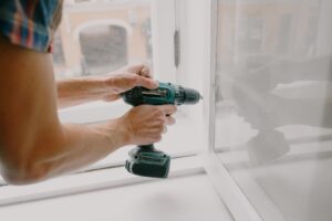 Imagen de un hombre realizando mantenimiento de marcos de ventana en una casa para renta