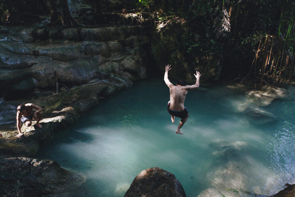 hombre saltando a un cenote disfrutando al rentar tu departamento en Valladolid.