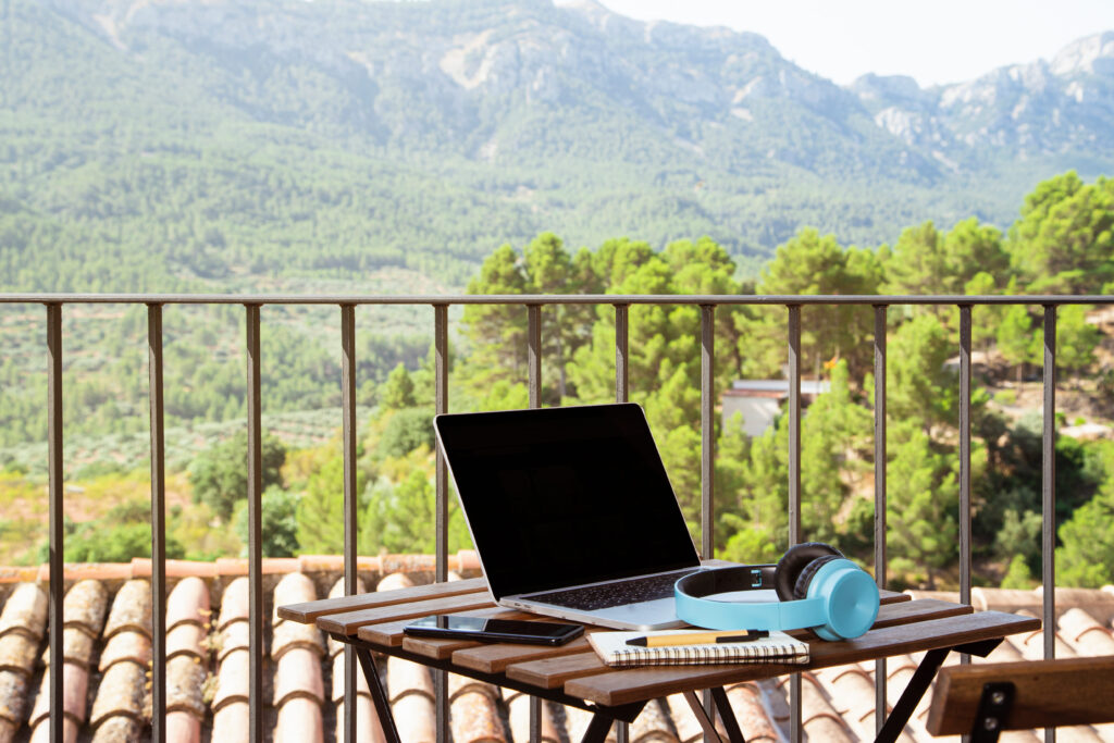 escritorio con los elementos que utilizan los nómadas digitales en México, con fondo de un paisaje natural