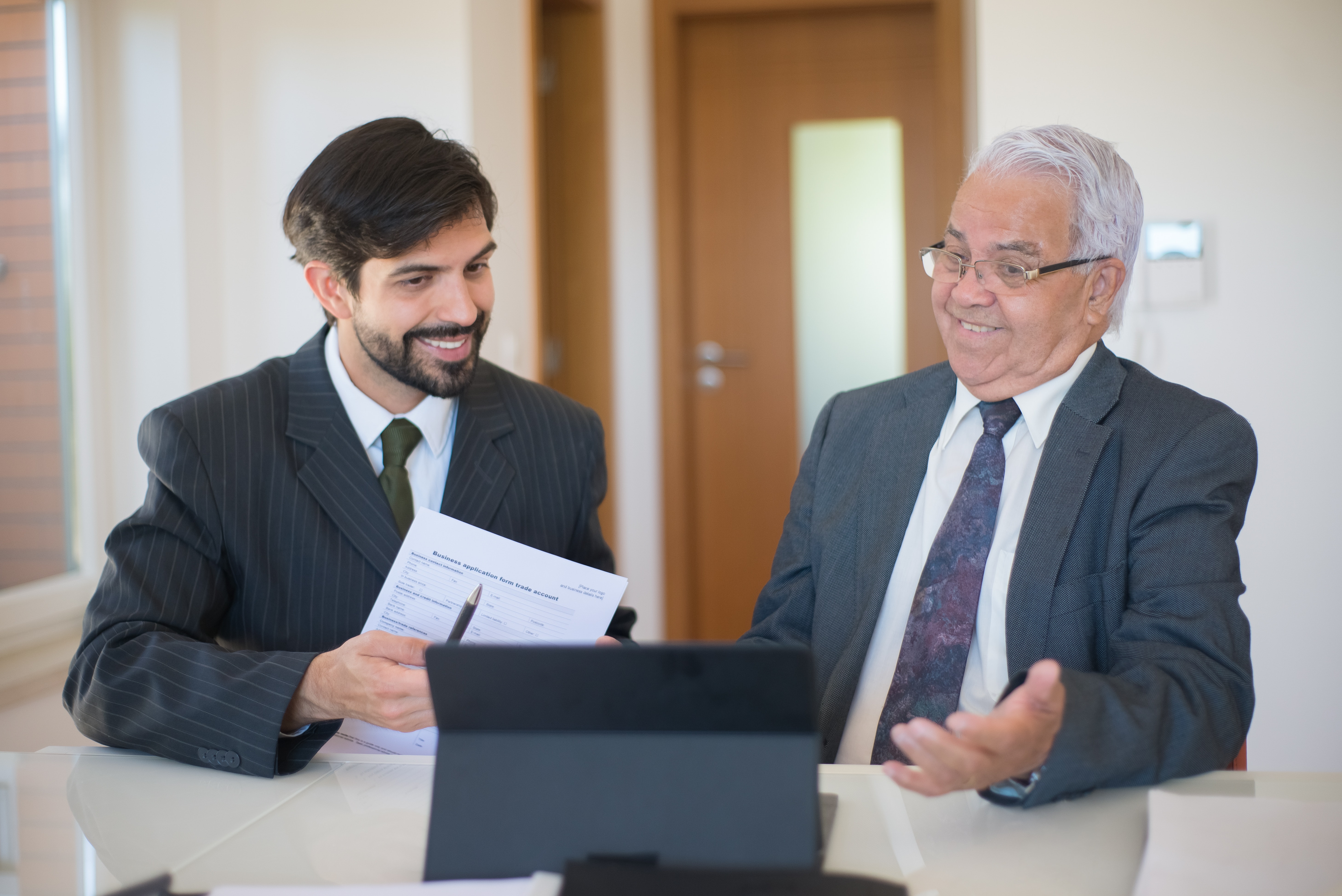 Agente inmobiliario y arrendador revisando contrato de arrendamiento.