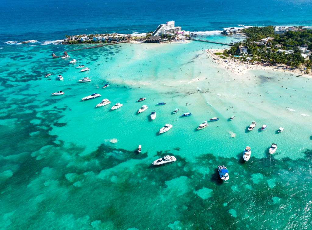 vista aérea de la playa norte, al fondo se ven inmuebles, ideales para rentar tu casa en Isla Mujeres 