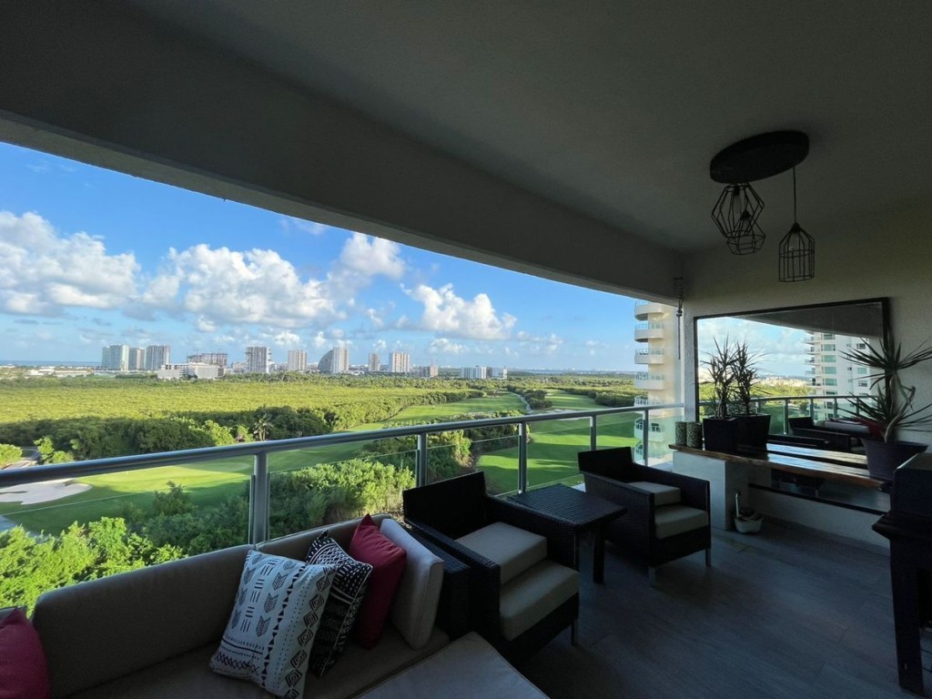 Interior de un departamento en renta en Cancún con vista a una zona verde.