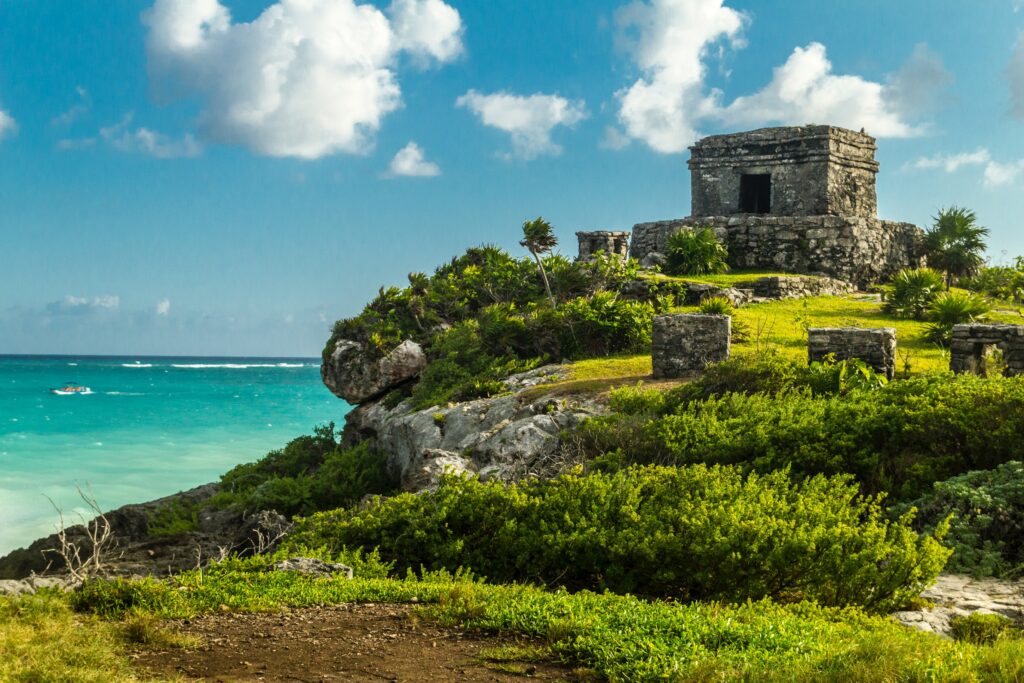 vista de una ruina de Tulum, cerca de una playa.
