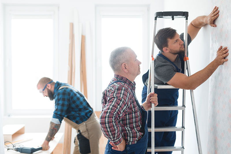 hombres dando mantenimiento a una casa