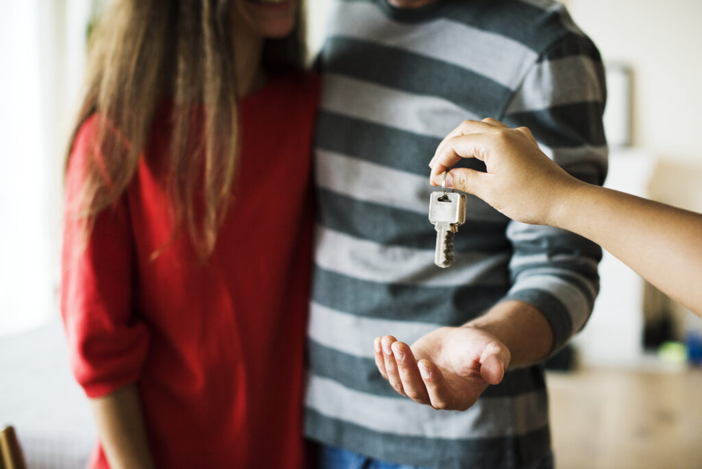 Pareja recibiendo llaves de una casa en alquiler sin saber si es legal subarrendar una vivienda